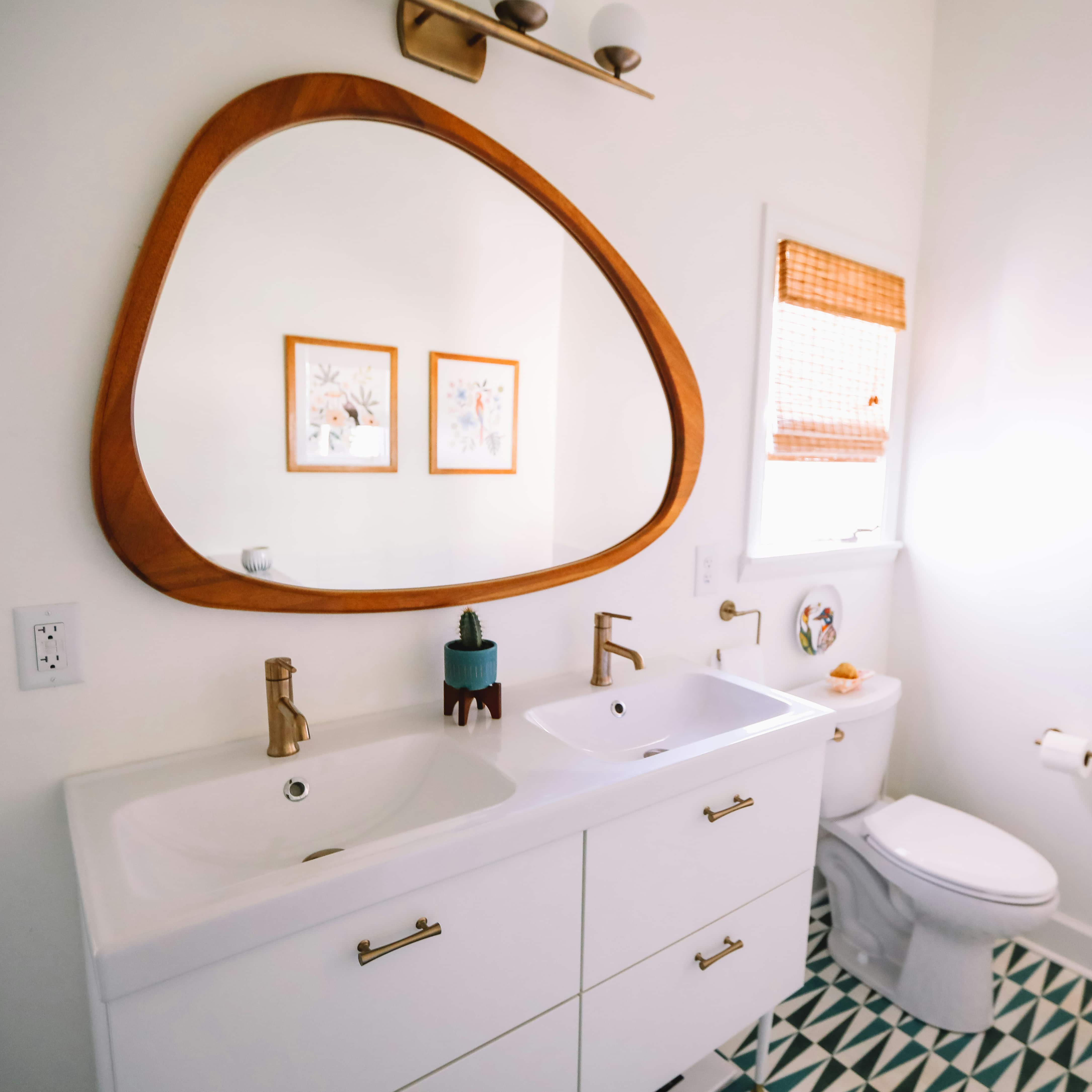 Aménager une petite salle de bain - Double vasque dans une salle de bain et grand miroir à la forme organique en bois