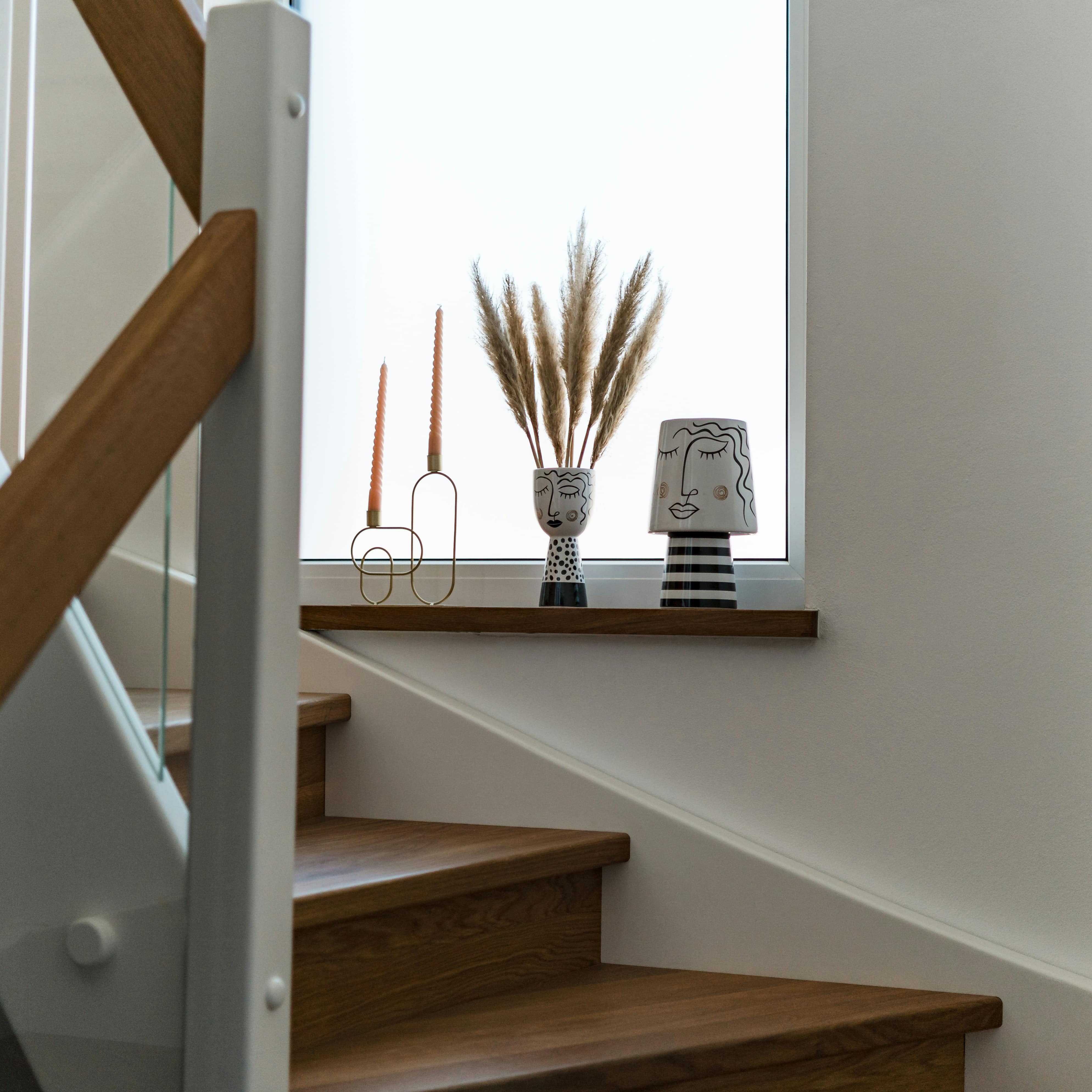 Comment rénover un escalier en bois - Un escalier avec de la petite décoration posée sur le rebord d'une fenêtre