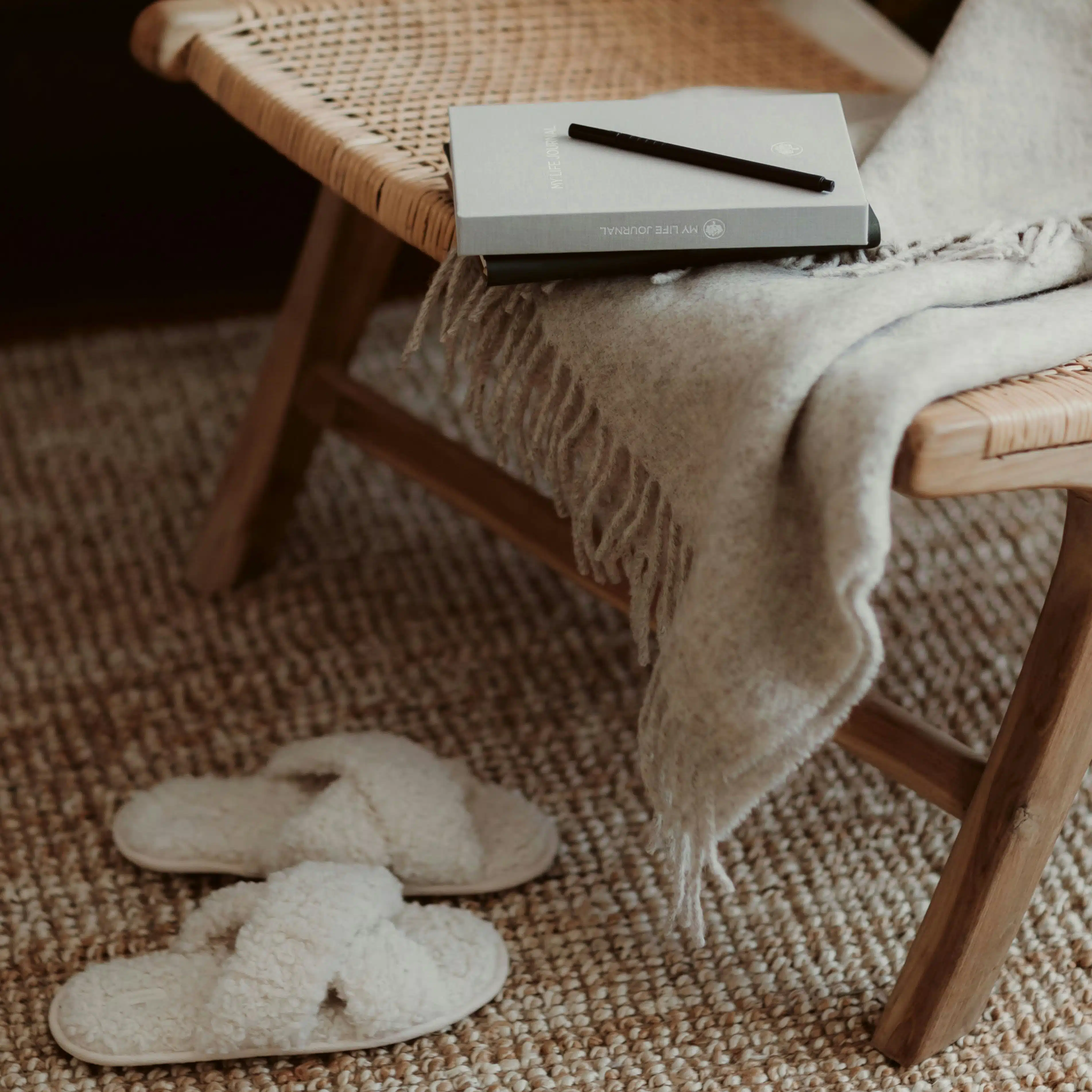 Le hygge : un mode de vie où règne l’art du slow living 1 Tendance Hygge - Une paire de chaussons, un plaid, un tapis et une chaise, des éléments de la déco Hygge