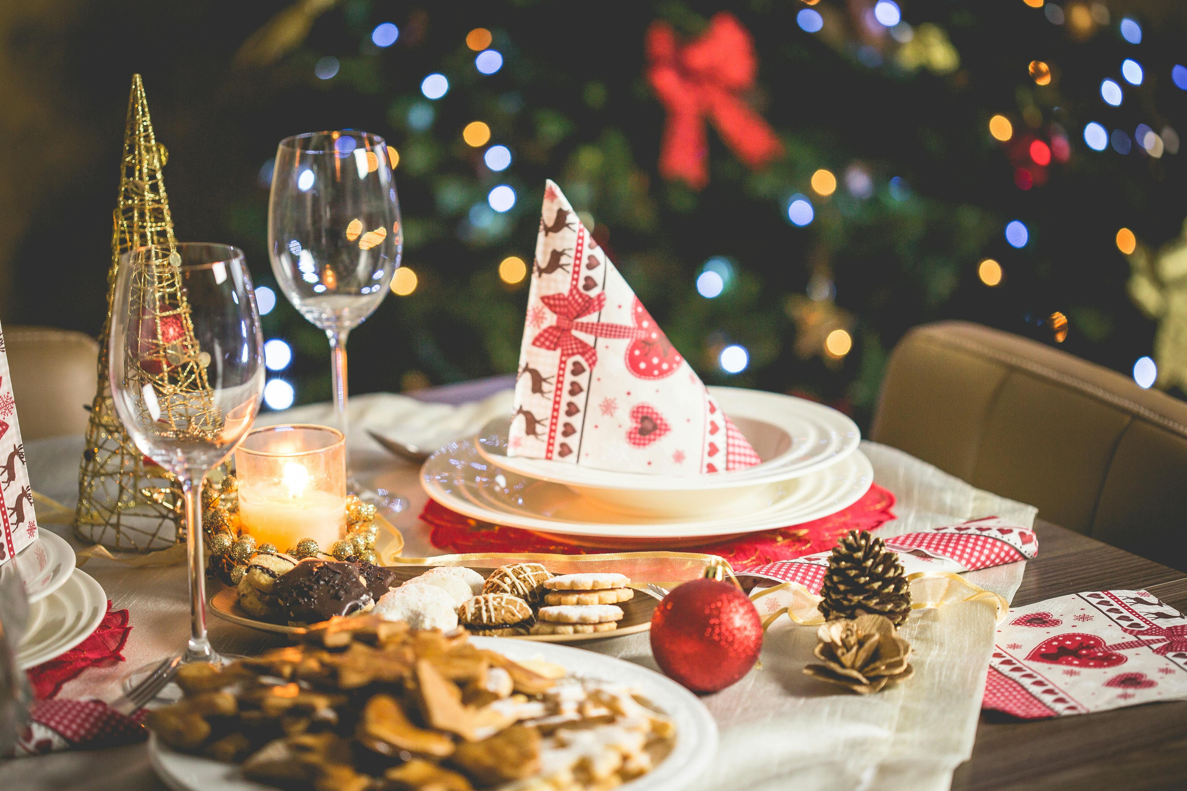 Comment décorer sa maison pour Noël - Une table décorée sur le thème de Noël avec des pommes de pin, des serviettes en papier et des biscuits.